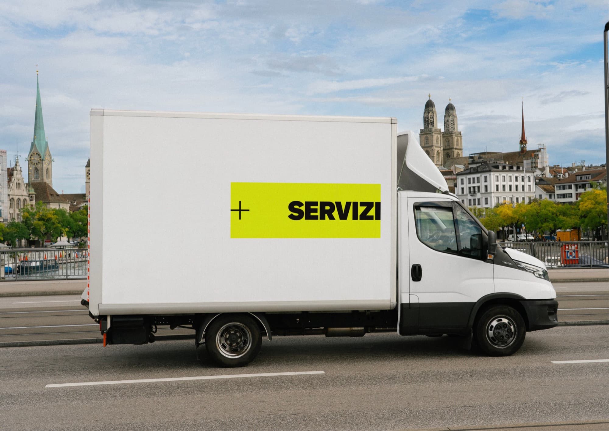 Furgone Più Servizi con il logo giallo sulla fiancata, in città